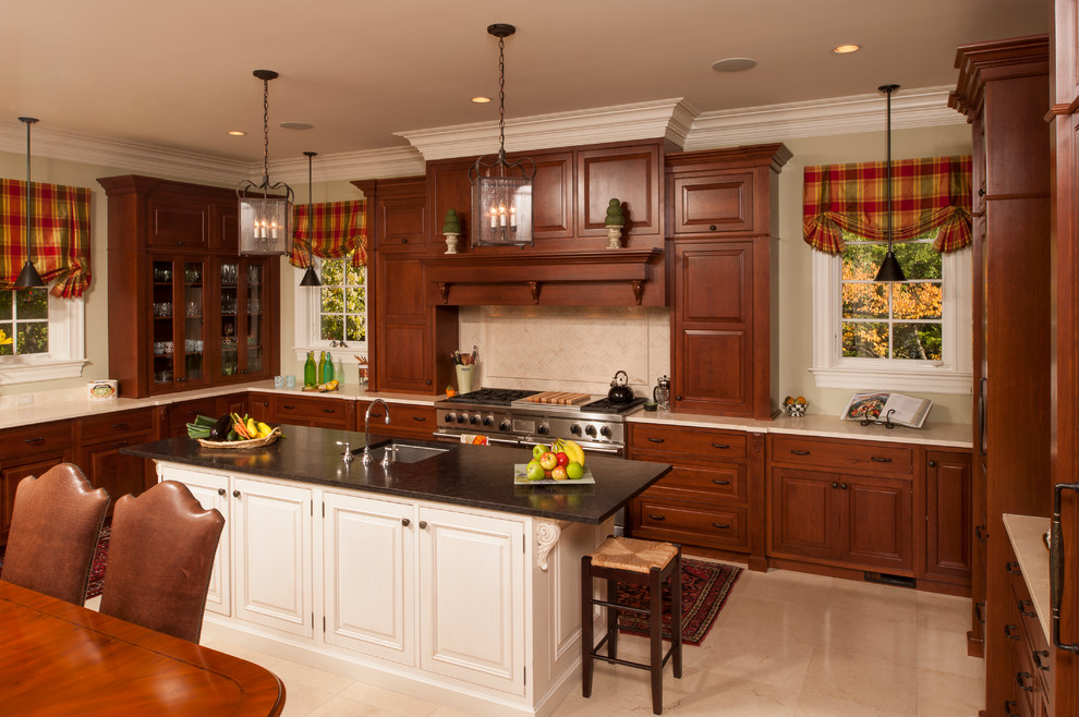 This is an example of a traditional u-shaped eat-in kitchen in Chicago with an undermount sink, raised-panel cabinets, dark wood cabinets, beige splashback and stainless steel appliances.