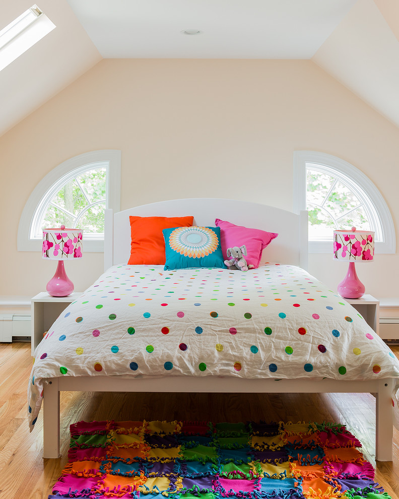 Photo of a transitional kids' bedroom for kids 4-10 years old and girls in Boston with beige walls and light hardwood floors.