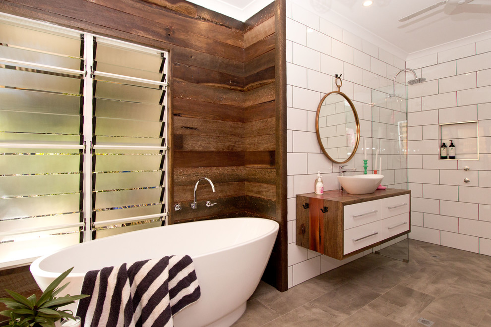 Inspiration for a mid-sized contemporary master bathroom in Dunedin with wood benchtops, a freestanding tub, white tile, subway tile, flat-panel cabinets, white cabinets, a vessel sink, porcelain floors and a curbless shower.