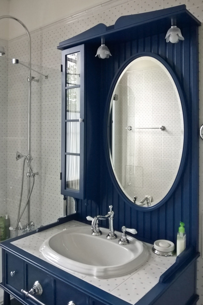 This is an example of a mid-sized traditional kids bathroom in Moscow with raised-panel cabinets, grey cabinets, an alcove tub, a shower/bathtub combo, a wall-mount toilet, white tile, ceramic tile, white walls, porcelain floors, a drop-in sink, grey floor, a shower curtain and white benchtops.