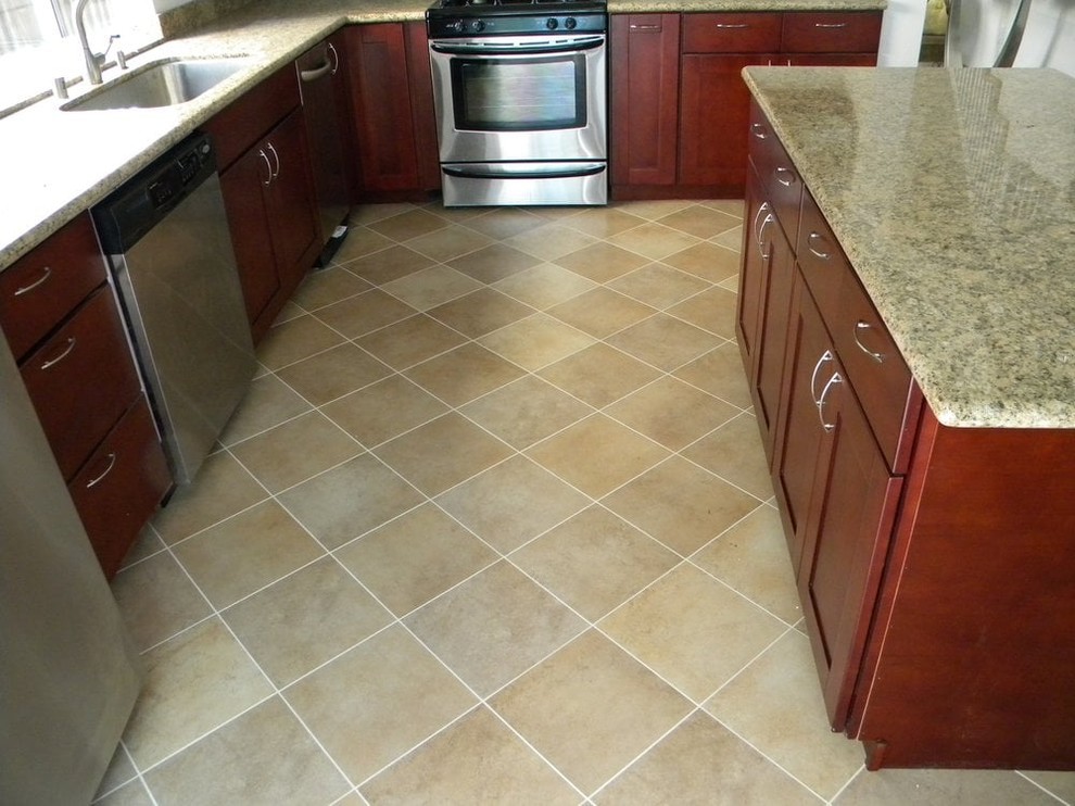 Example of a mid-sized transitional u-shaped medium tone wood floor and brown floor kitchen design in San Francisco with an undermount sink, shaker cabinets, dark wood cabinets, granite countertops, white backsplash, stone slab backsplash and stainless steel appliances