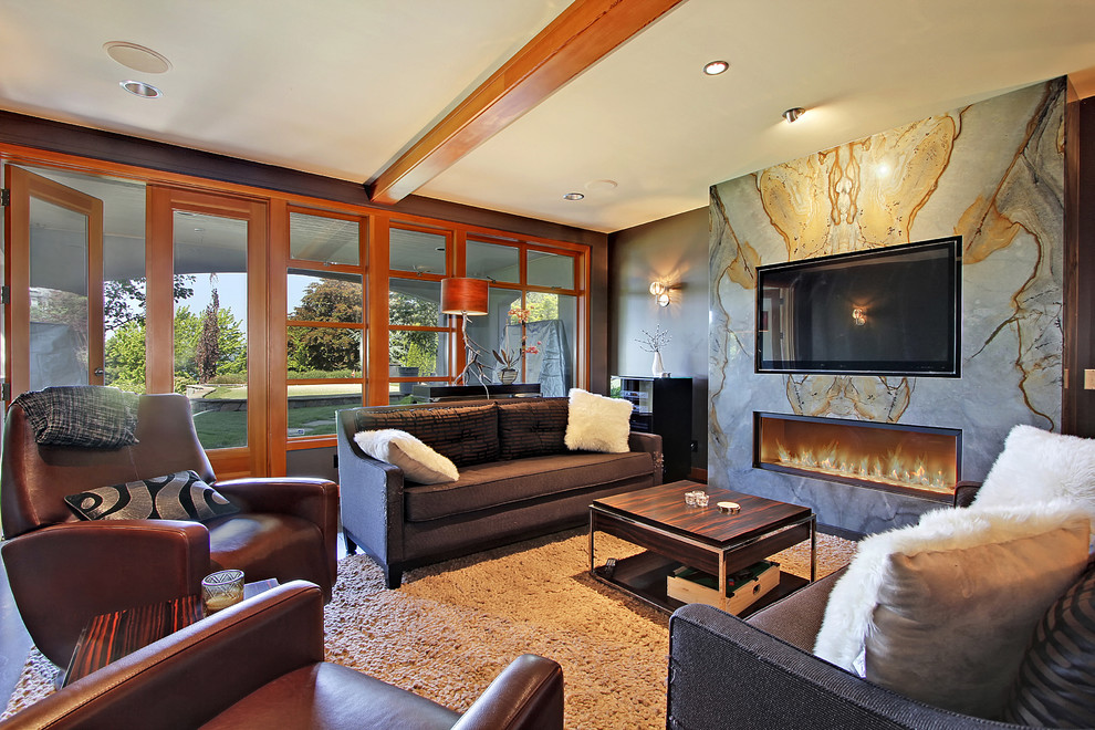 This is an example of a contemporary living room in Seattle with a built-in media wall, a ribbon fireplace and a stone fireplace surround.