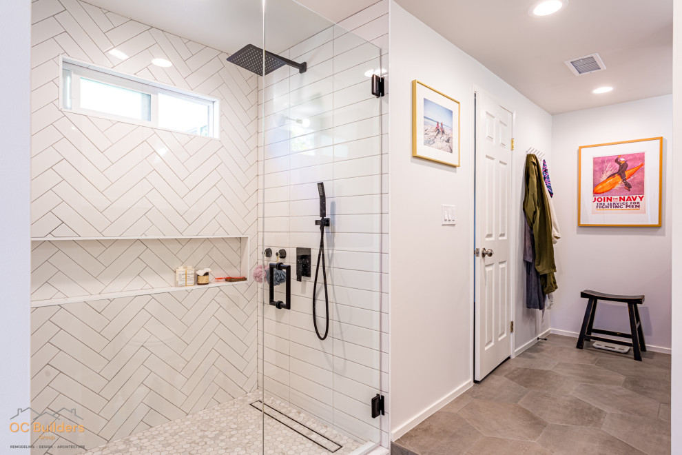 Photo of a mid-sized beach style master bathroom in Orange County with shaker cabinets, blue cabinets, an alcove shower, a one-piece toilet, white tile, ceramic tile, white walls, ceramic floors, an undermount sink, solid surface benchtops, beige floor, a hinged shower door, white benchtops, a niche, a double vanity and a built-in vanity.