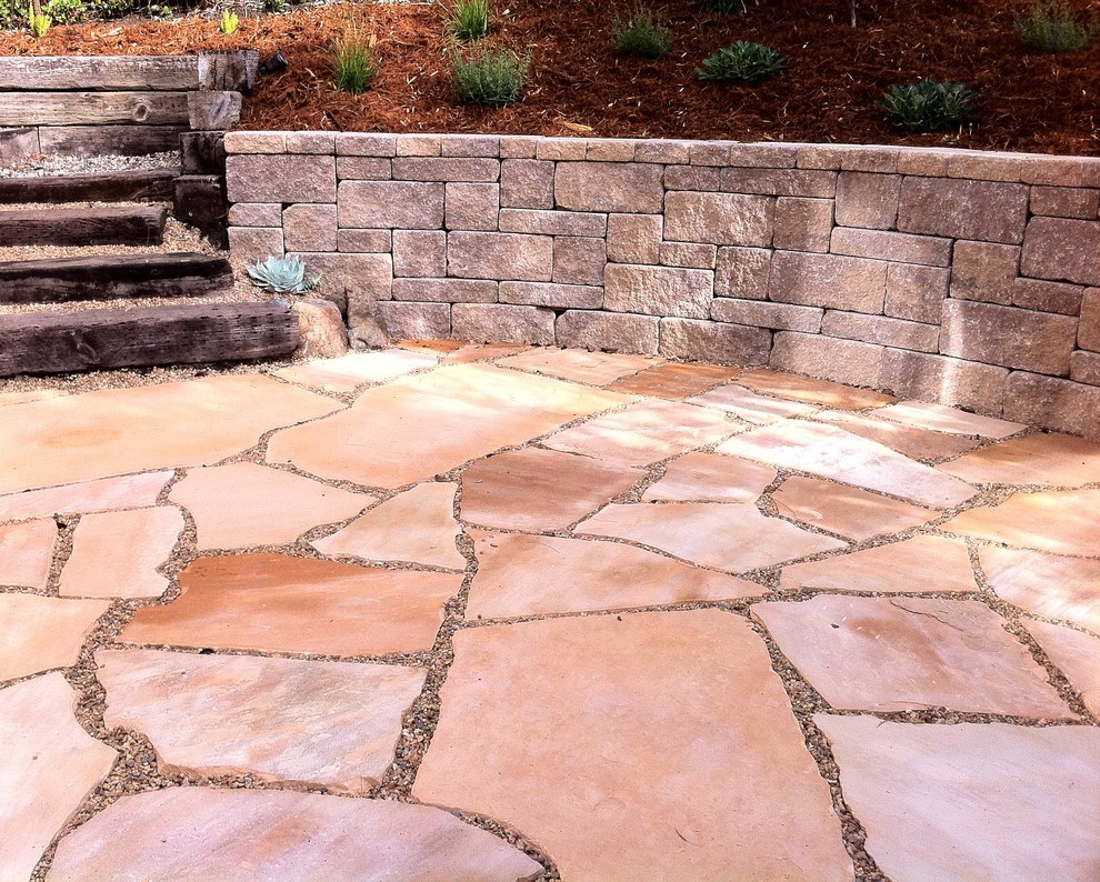 This is an example of a mediterranean garden in San Luis Obispo with a retaining wall and natural stone pavers.
