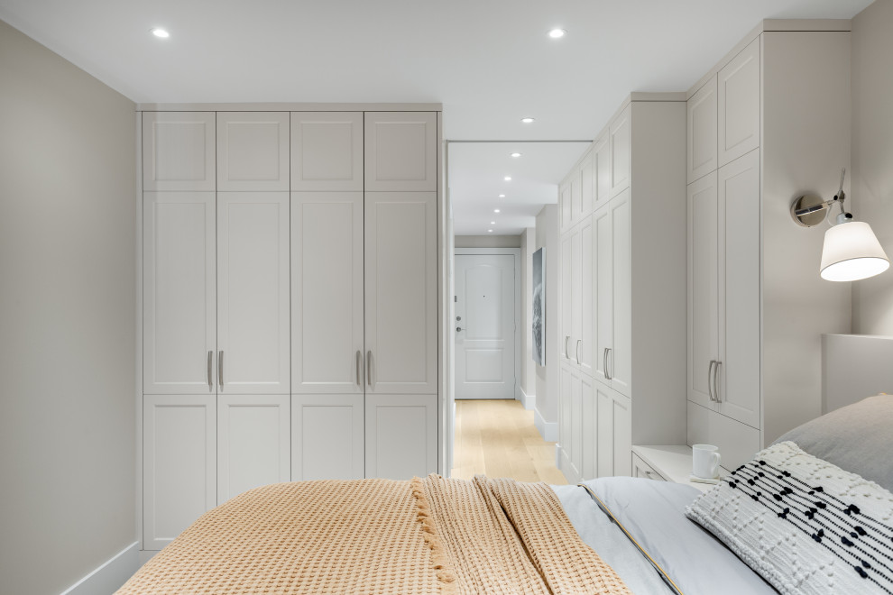 Imagen de dormitorio principal y blanco tradicional renovado pequeño sin chimenea con paredes blancas y suelo marrón