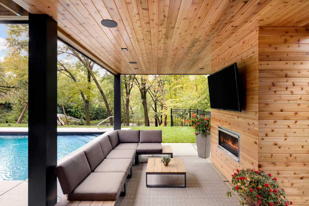 Inspiration for a contemporary backyard patio in Minneapolis with with fireplace and a roof extension.