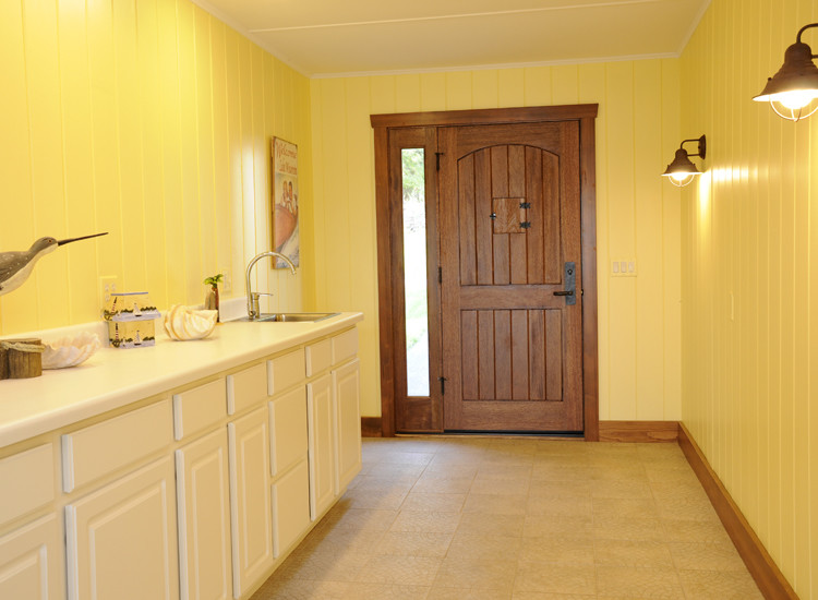 Inspiration for a coastal front door remodel with yellow walls and a brown front door