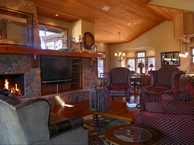 Photo of a large arts and crafts open concept family room in Phoenix with beige walls, medium hardwood floors, a standard fireplace, a stone fireplace surround and a built-in media wall.
