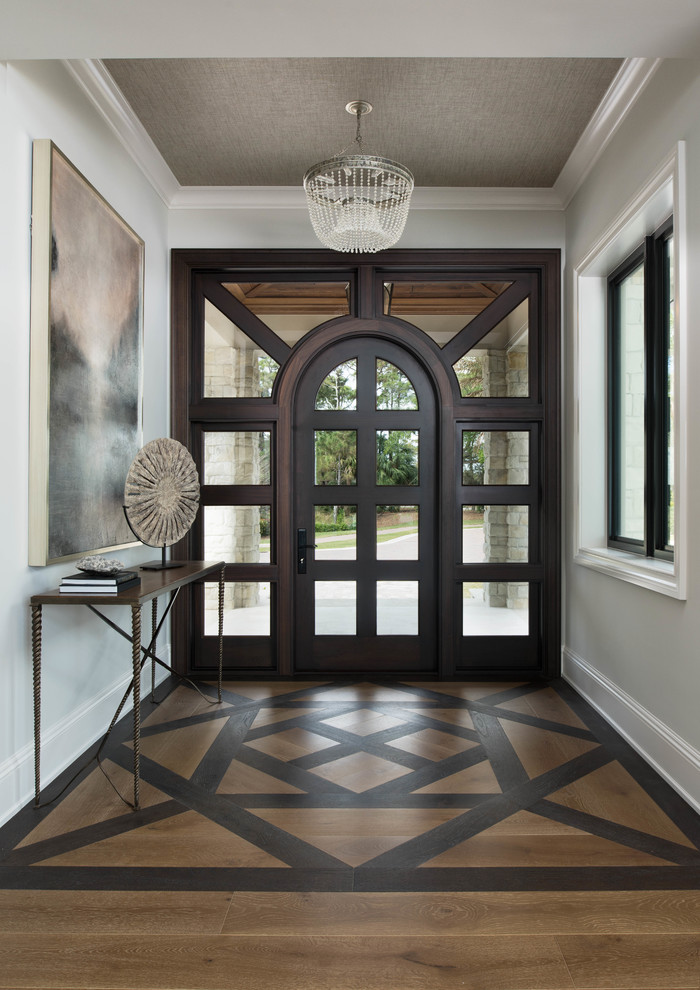 Design ideas for a large transitional foyer in Miami with grey walls, dark hardwood floors, a single front door, a glass front door, brown floor and wallpaper.