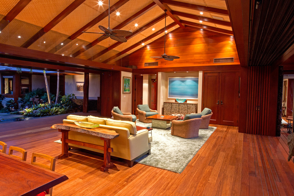 Photo of a large arts and crafts formal open concept living room in Hawaii with multi-coloured walls, bamboo floors, no fireplace and a concealed tv.