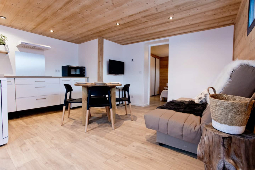 Exemple d'une grande salle de séjour scandinave ouverte avec un mur blanc, sol en stratifié, aucune cheminée, un téléviseur fixé au mur et un plafond en bois.