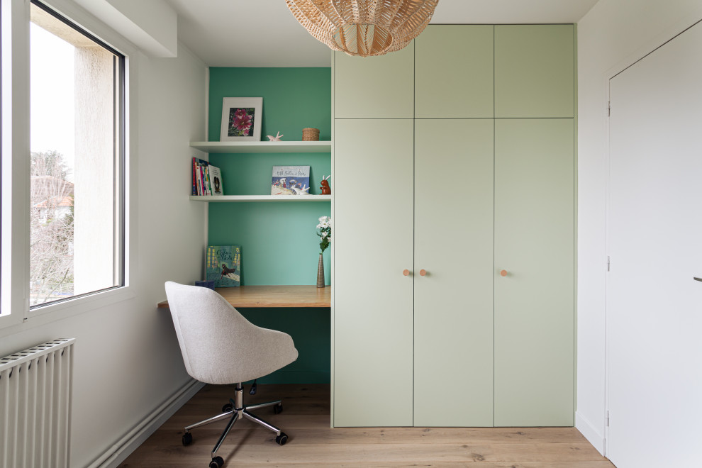 Idéer för att renovera ett mellanstort skandinaviskt könsneutralt tonårsrum kombinerat med sovrum, med gröna väggar och ljust trägolv