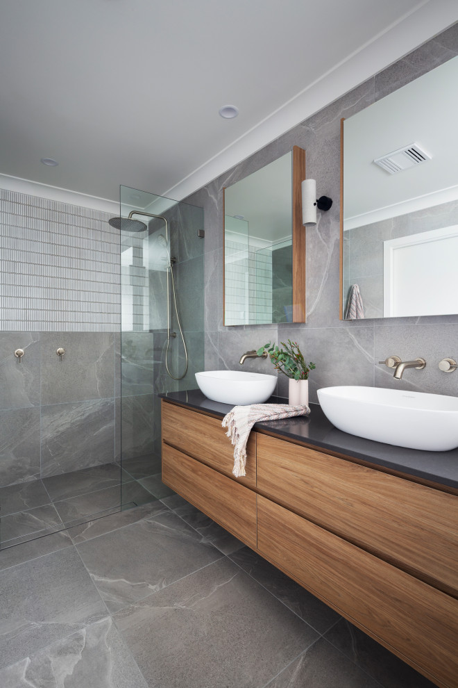 Ejemplo de cuarto de baño doble y flotante actual de tamaño medio con baldosas y/o azulejos grises, baldosas y/o azulejos de piedra, aseo y ducha y encimera de cuarzo compacto