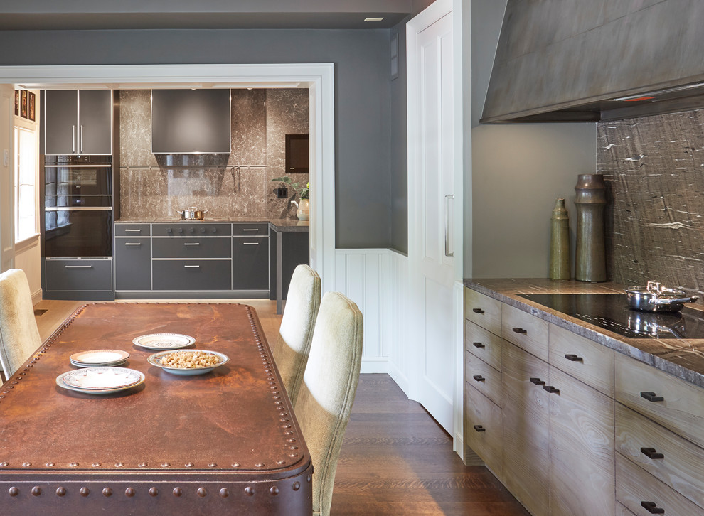 This is an example of a mid-sized traditional l-shaped separate kitchen in Chicago with an integrated sink, flat-panel cabinets, grey cabinets, quartz benchtops, multi-coloured splashback, porcelain splashback, panelled appliances, medium hardwood floors, with island, black floor and grey benchtop.