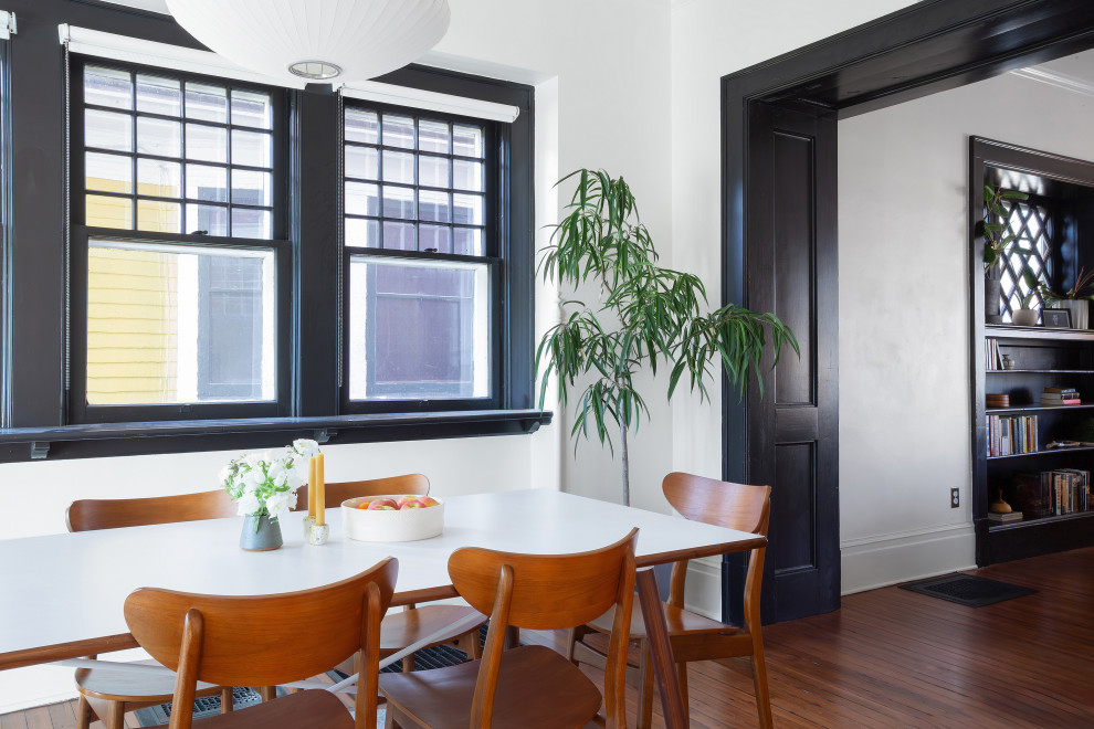 Idées déco pour une salle à manger ouverte sur la cuisine craftsman avec un mur blanc, un sol en bois brun et un sol marron.