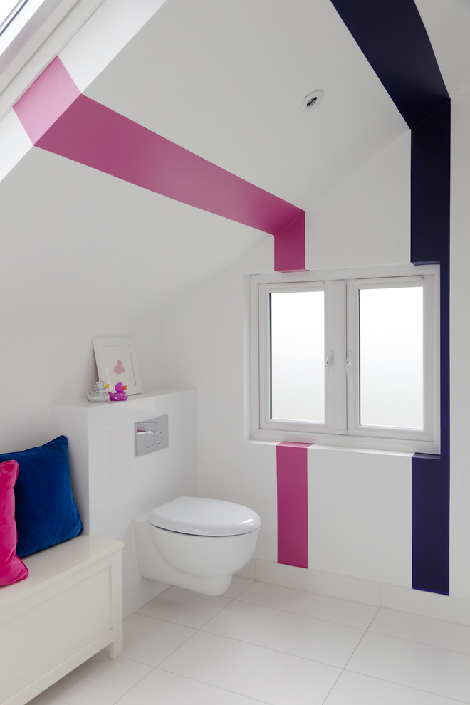 This is an example of a mid-sized contemporary kids bathroom in London with a wall-mount toilet, multi-coloured walls, white tile, ceramic tile and ceramic floors.