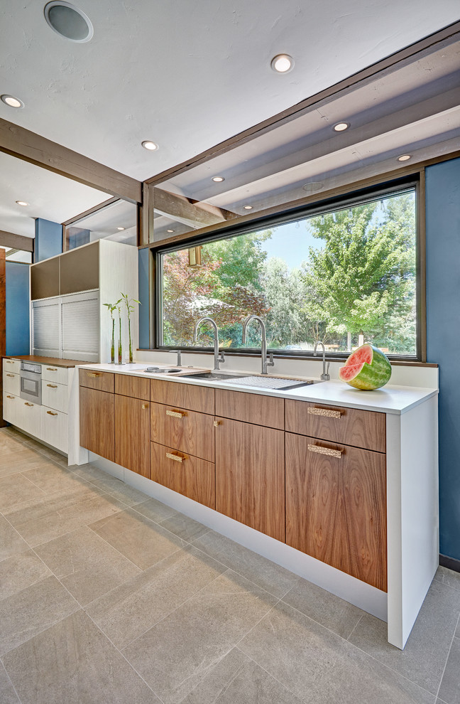 Inspiration for a mid-sized midcentury l-shaped open plan kitchen in Sacramento with an undermount sink, flat-panel cabinets, white cabinets, quartz benchtops, white splashback, stone slab splashback, white appliances, porcelain floors, with island and grey floor.