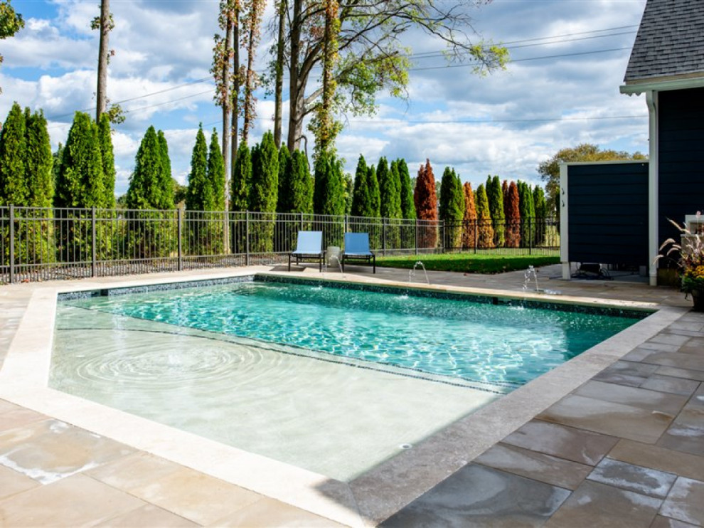 Bild på en liten funkis anpassad pool på baksidan av huset, med en fontän och naturstensplattor