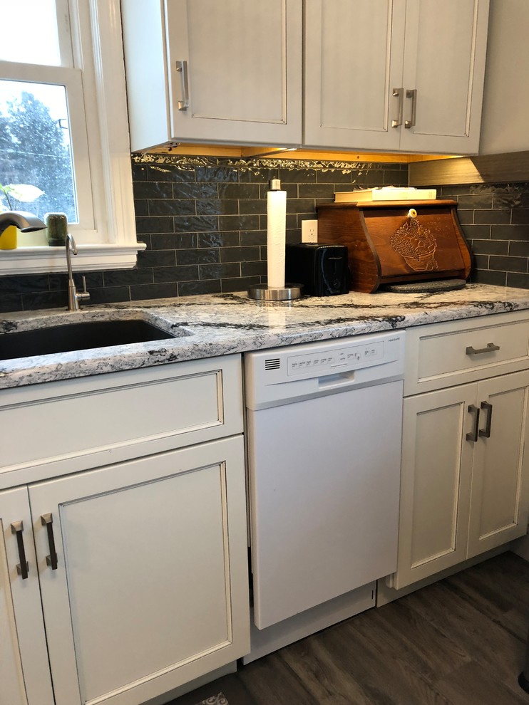 Inspiration for a small transitional l-shaped laminate floor and gray floor eat-in kitchen remodel with an undermount sink, flat-panel cabinets, white cabinets, quartz countertops, gray backsplash, subway tile backsplash, white appliances and white countertops