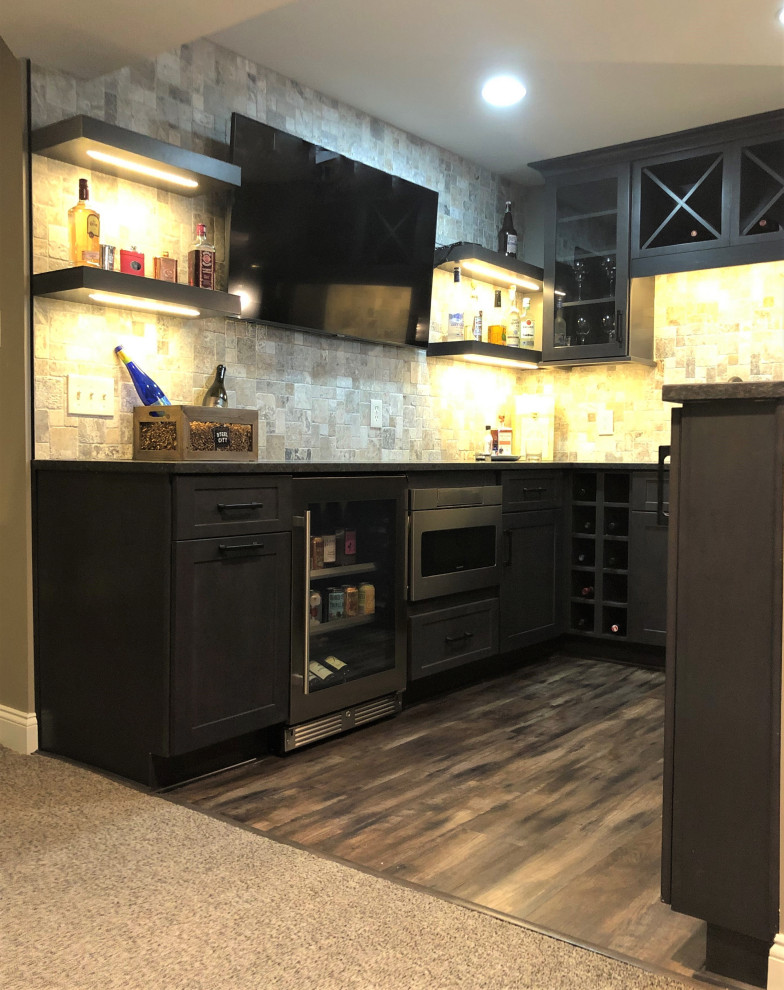 Inspiration for a small country u-shaped wet bar in Other with an undermount sink, flat-panel cabinets, dark wood cabinets, granite benchtops, grey splashback, travertine splashback, vinyl floors, brown floor and brown benchtop.