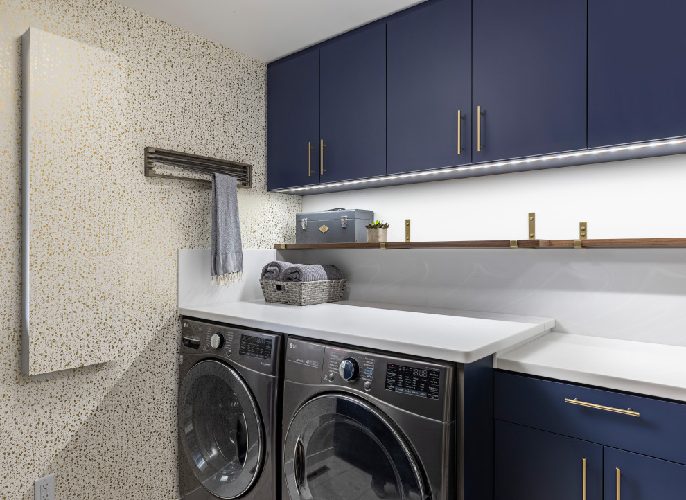 Exempel på en 50 tals vita parallell vitt tvättstuga enbart för tvätt, med blå skåp, en tvättmaskin och torktumlare bredvid varandra, släta luckor, bänkskiva i kvarts och vita väggar