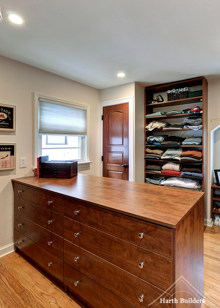 Design ideas for a mid-sized transitional men's walk-in wardrobe in Philadelphia with flat-panel cabinets and medium wood cabinets.