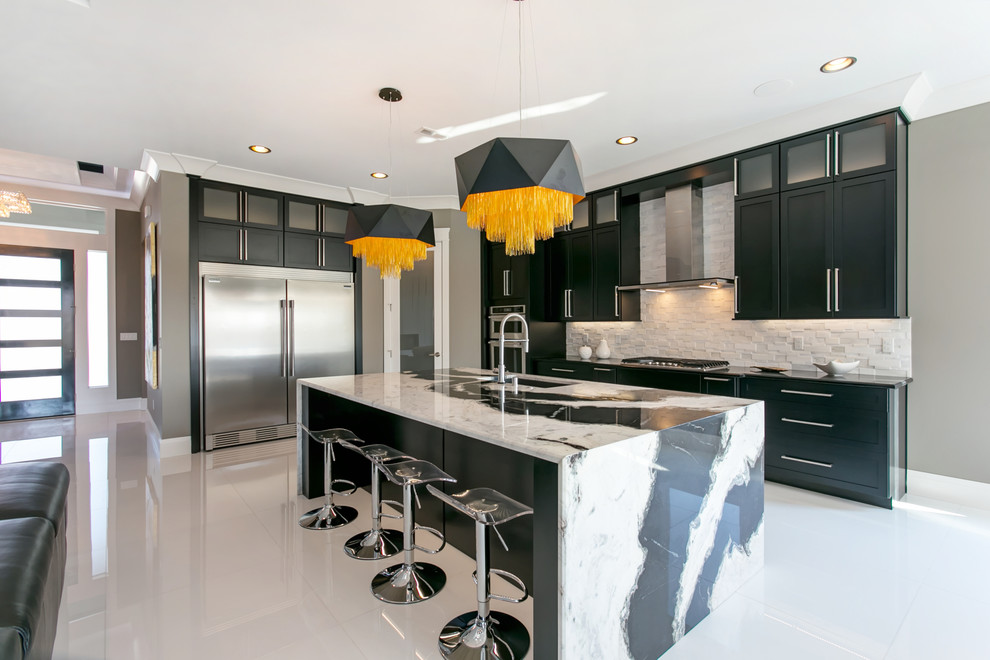 Example of a large trendy l-shaped white floor open concept kitchen design in Seattle with an undermount sink, shaker cabinets, black cabinets, granite countertops, white backsplash, stone tile backsplash, stainless steel appliances and an island