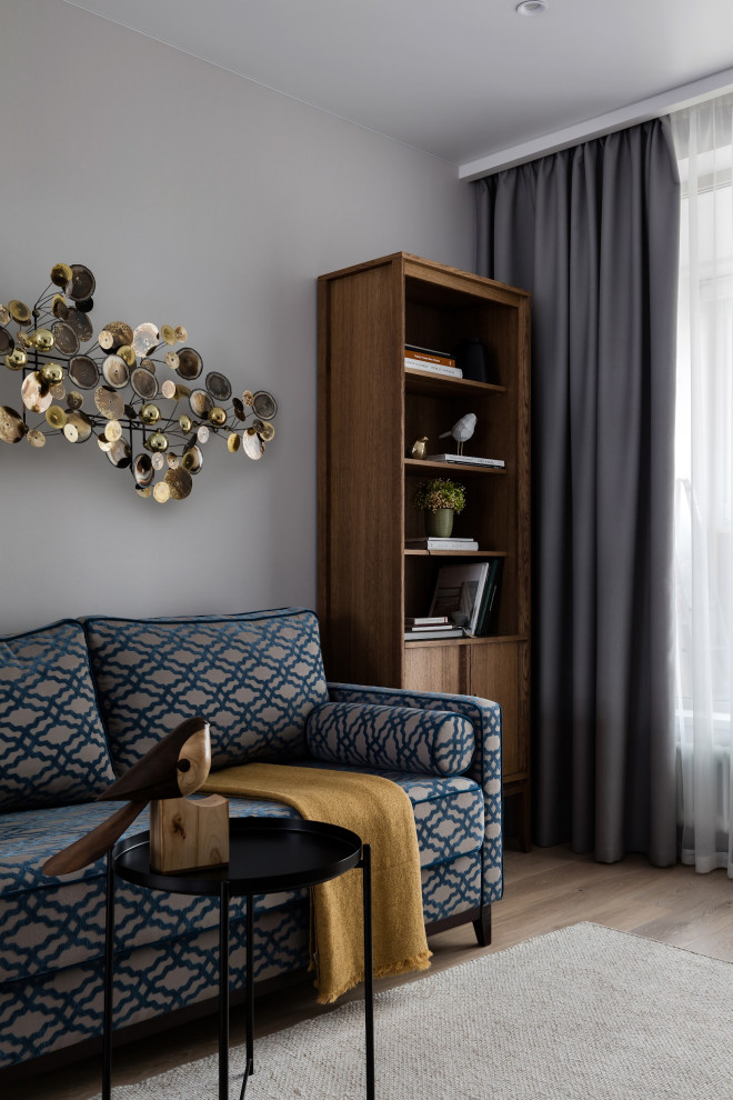 Immagine di un piccolo soggiorno minimal con libreria, pareti grigie, pavimento in legno massello medio e TV autoportante