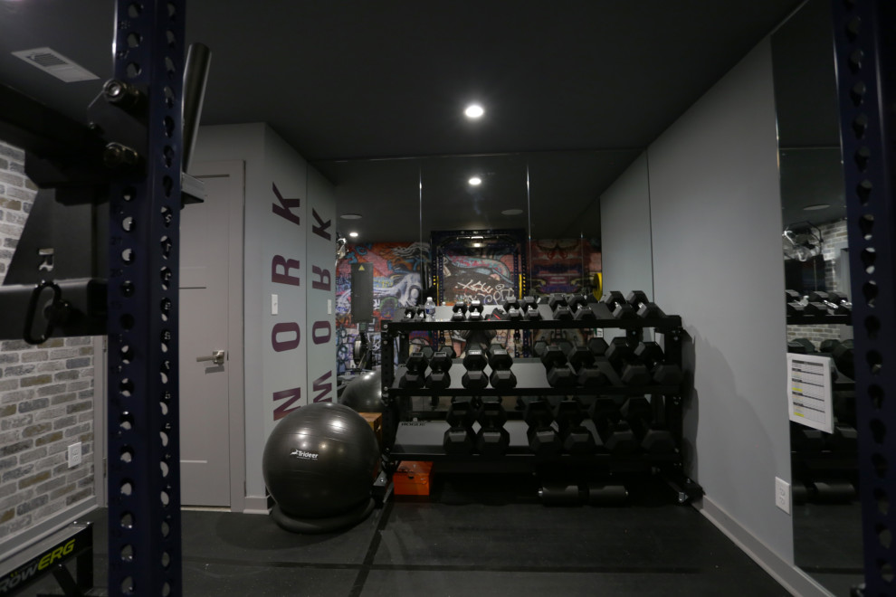 Ejemplo de gimnasio multiusos actual pequeño con paredes grises y suelo negro