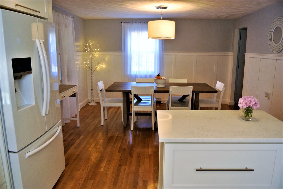 Example of a transitional u-shaped medium tone wood floor eat-in kitchen design in Boston with shaker cabinets, an undermount sink, white cabinets, white backsplash, white appliances and a peninsula