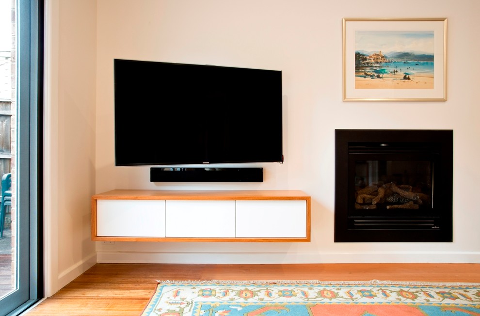 Photo of a small contemporary open concept living room in Melbourne with white walls, light hardwood floors and a wall-mounted tv.