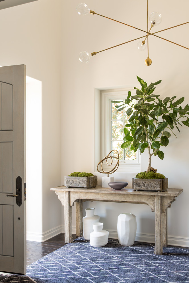 This is an example of a transitional entryway in Los Angeles with white walls, dark hardwood floors, a single front door, a gray front door and brown floor.