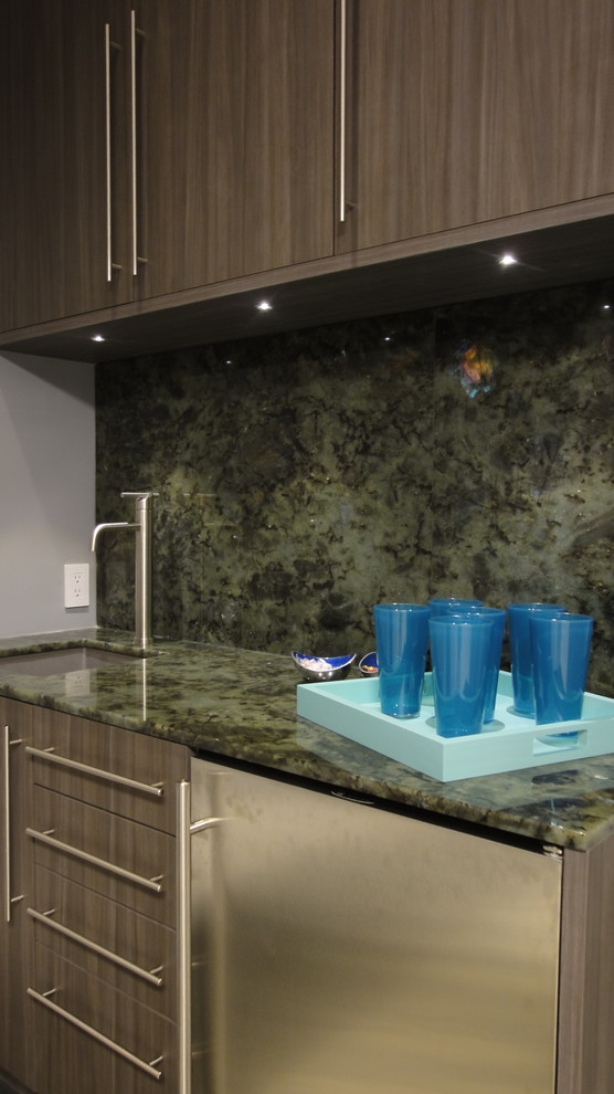 This is an example of a small modern galley wet bar in Houston with an undermount sink, flat-panel cabinets, green splashback, stone slab splashback, porcelain floors and brown cabinets.