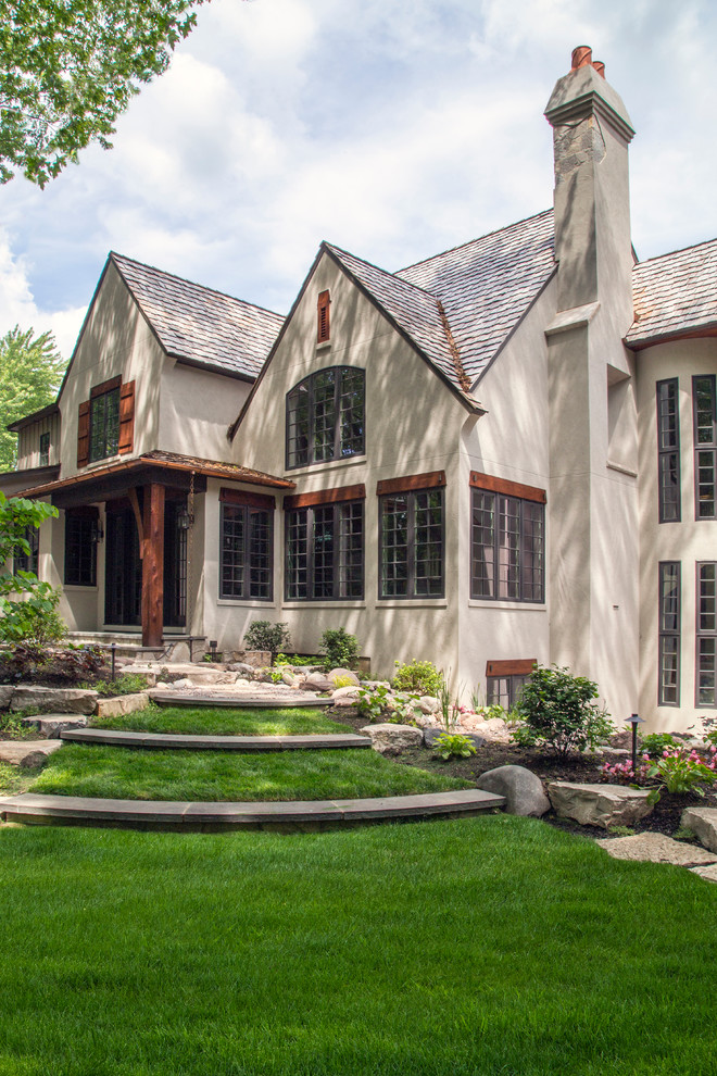 Expansive traditional two-storey stucco beige exterior in Chicago with a gable roof.