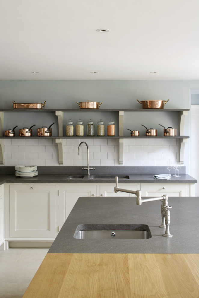 Photo of a large transitional l-shaped separate kitchen in Hampshire with a drop-in sink, recessed-panel cabinets, wood benchtops, white splashback, subway tile splashback, coloured appliances, limestone floors and with island.