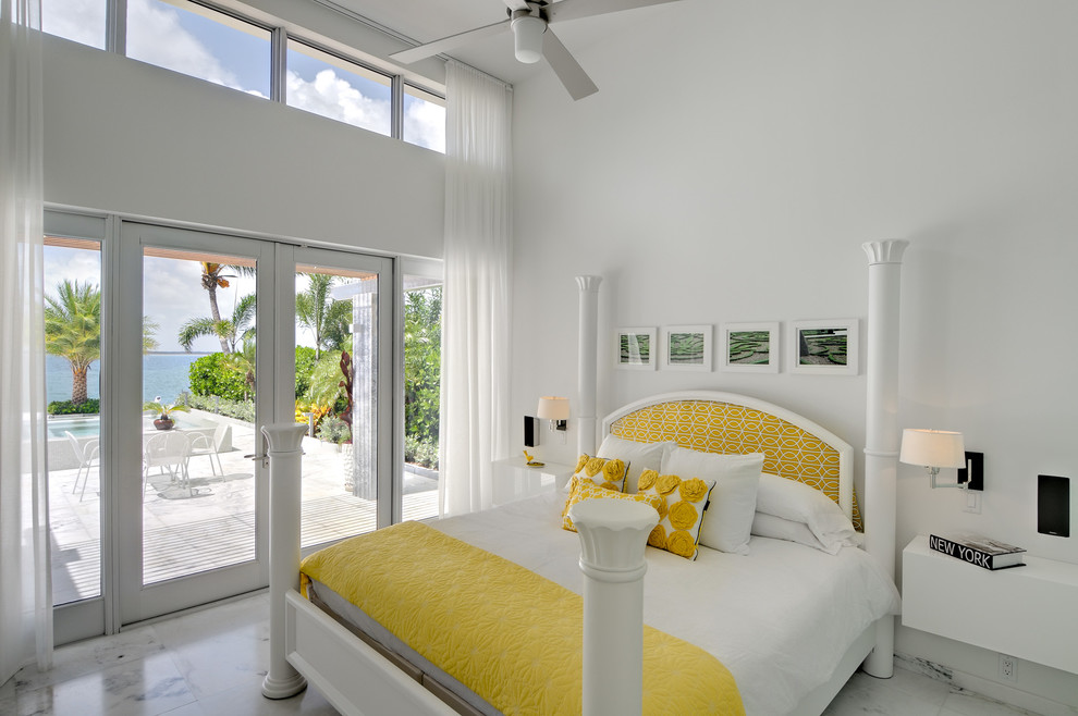 Design ideas for a tropical master bedroom in Miami with white walls and no fireplace.