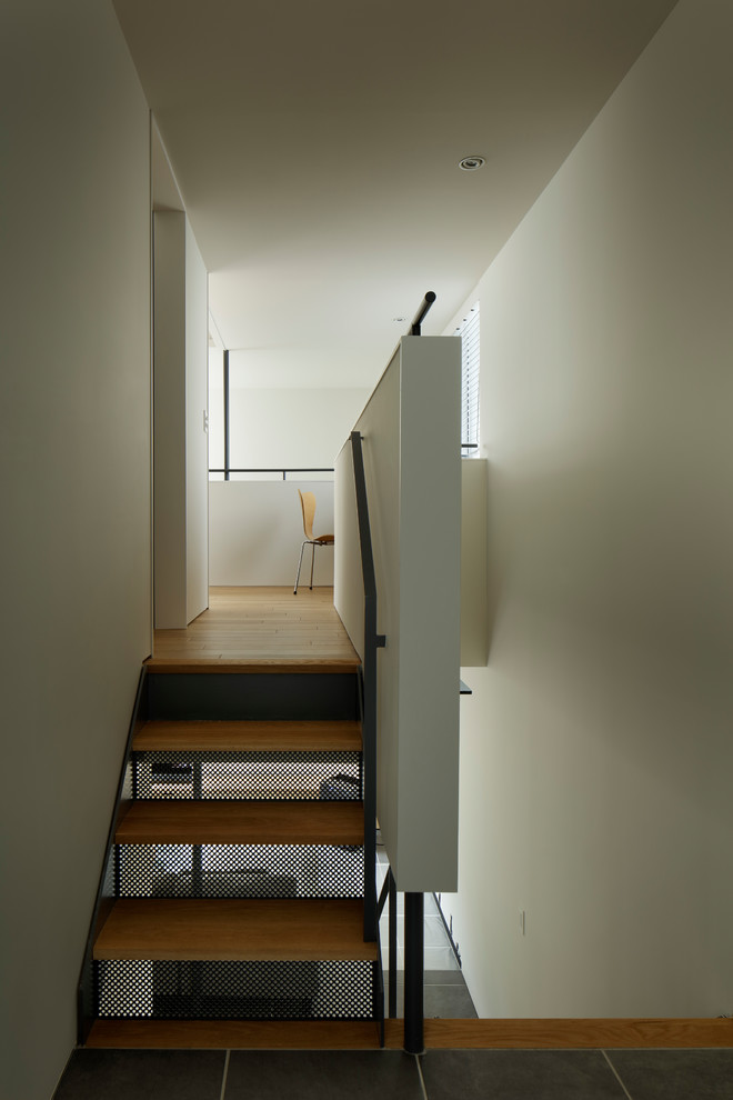 Inspiration for a contemporary wood staircase in Yokohama with metal risers and metal railing.