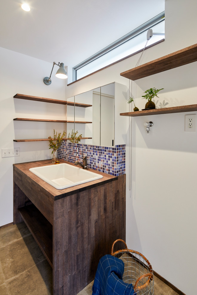 World-inspired cloakroom in Other with open cabinets, dark wood cabinets, multi-coloured tiles, mosaic tiles, white walls, vinyl flooring, a submerged sink, wooden worktops, grey floors, brown worktops, a built in vanity unit, a wallpapered ceiling and wallpapered walls.