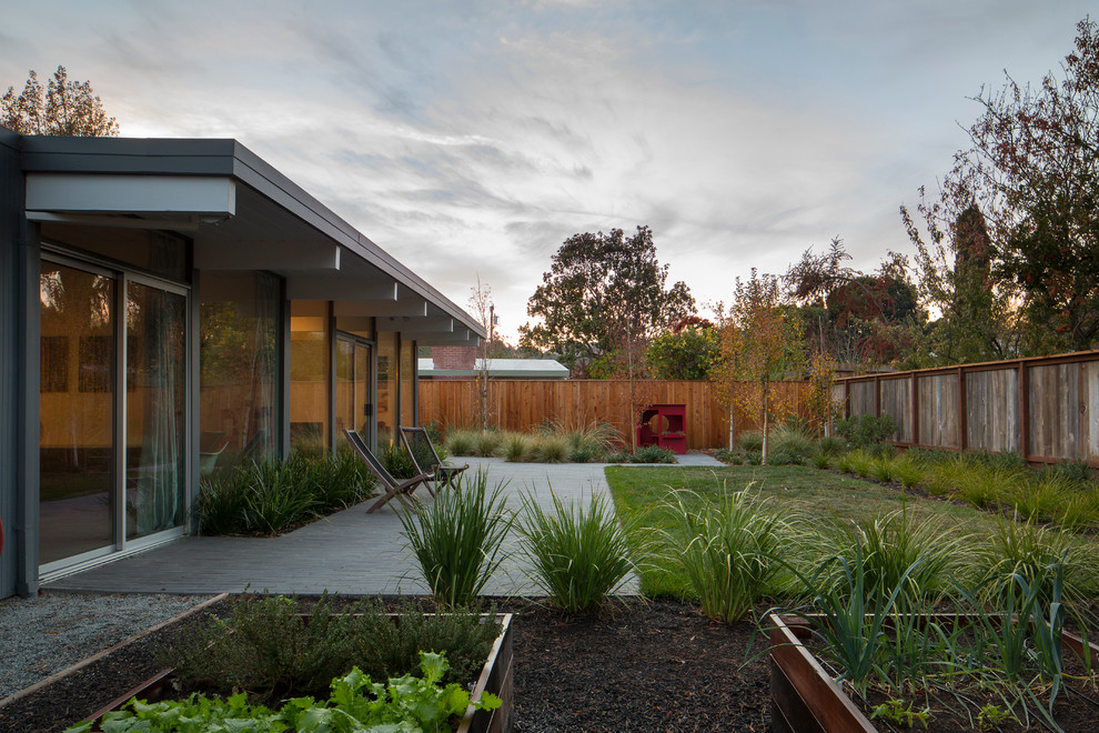 Photo of a huge mid-century modern drought-tolerant and full sun backyard concrete paver and wood fence vegetable garden landscape in San Francisco for summer.