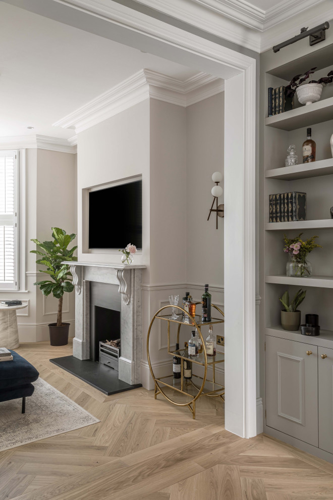 This is an example of a mid-sized modern formal open concept living room in London with grey walls, medium hardwood floors, a standard fireplace, a stone fireplace surround, a wall-mounted tv, brown floor and panelled walls.