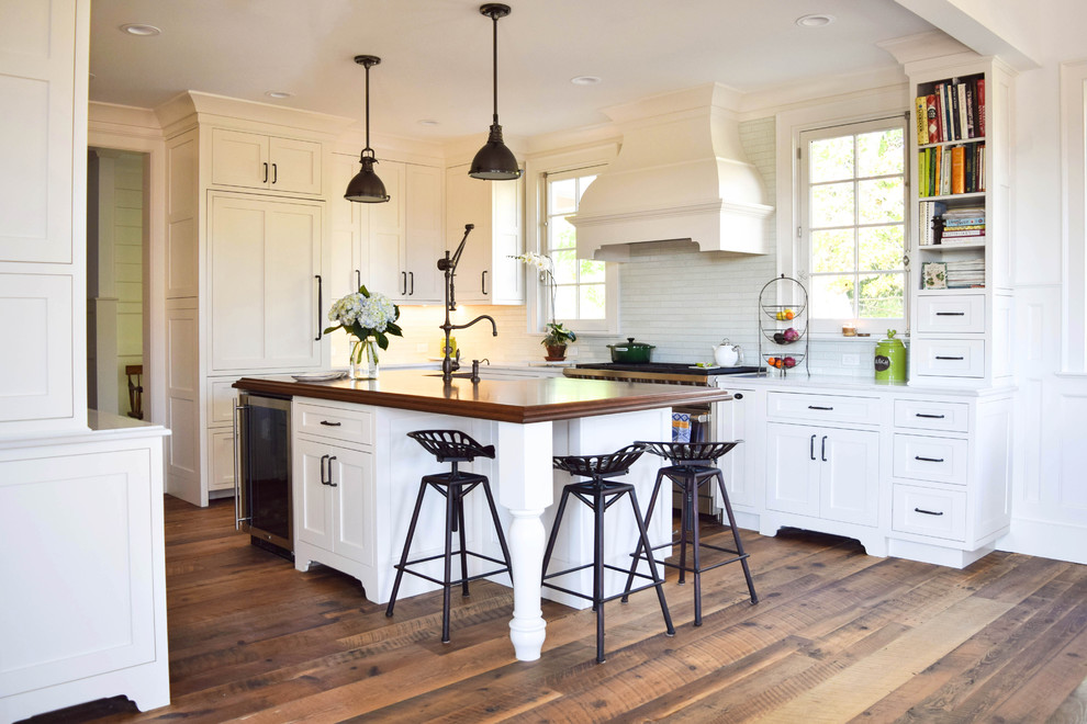 Design ideas for a large country galley eat-in kitchen in New York with a farmhouse sink, recessed-panel cabinets, white cabinets, wood benchtops, blue splashback, glass tile splashback, stainless steel appliances, medium hardwood floors and with island.