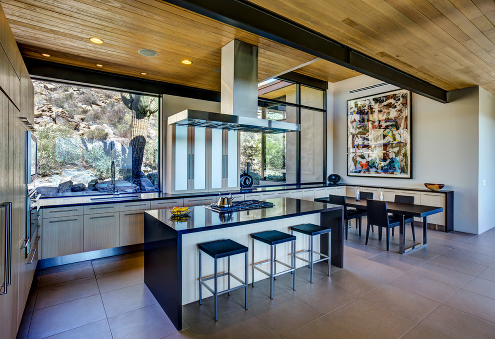 This is an example of a mid-sized contemporary u-shaped eat-in kitchen in Phoenix with an undermount sink, flat-panel cabinets, light wood cabinets, quartz benchtops, stainless steel appliances, porcelain floors, with island and beige floor.