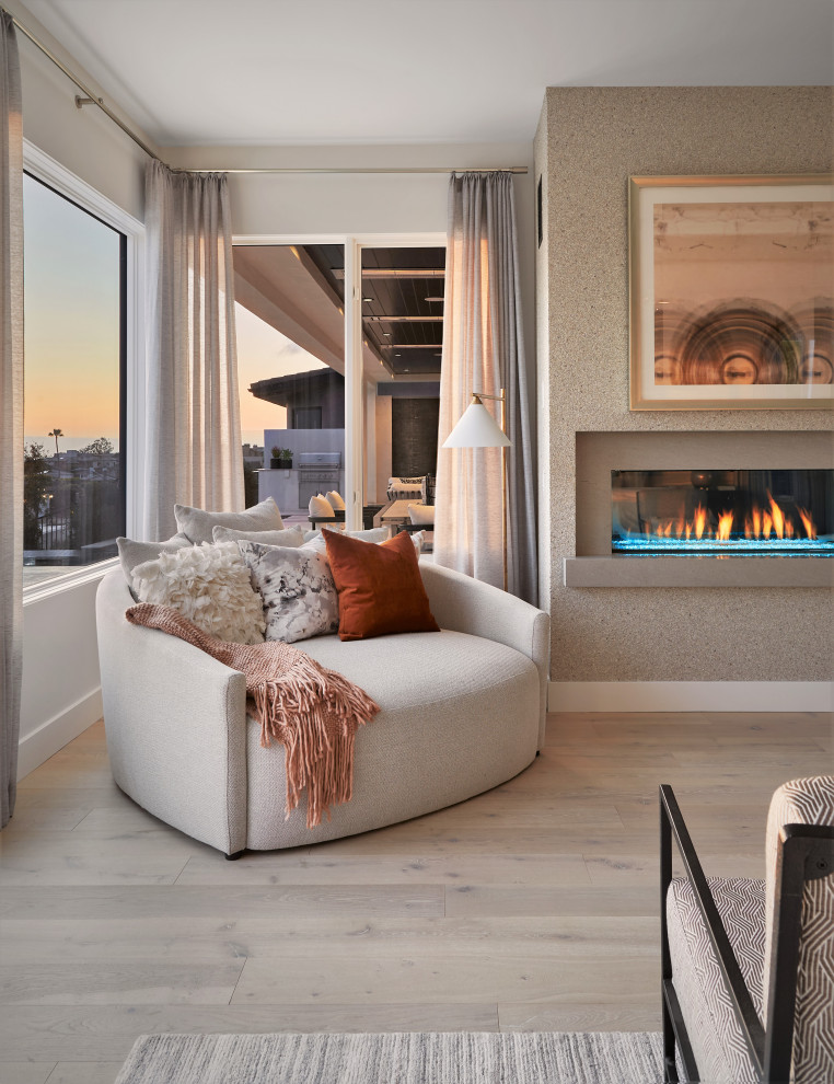 Photo of a large contemporary master bedroom in Orange County with white walls, medium hardwood flooring, a standard fireplace and wallpapered walls.