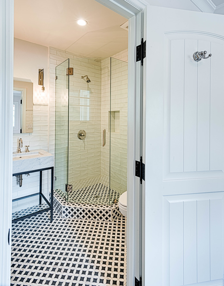 This is an example of a small transitional 3/4 bathroom in Los Angeles with open cabinets, black cabinets, a corner shower, a two-piece toilet, white tile, subway tile, white walls, cement tiles, an undermount sink, marble benchtops, multi-coloured floor, a hinged shower door and white benchtops.