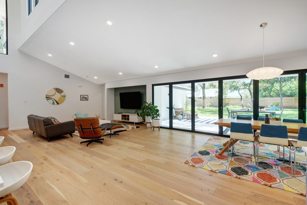 Foto di un grande soggiorno scandinavo aperto con angolo bar, pareti verdi, parquet chiaro, TV a parete, pavimento marrone e soffitto a volta