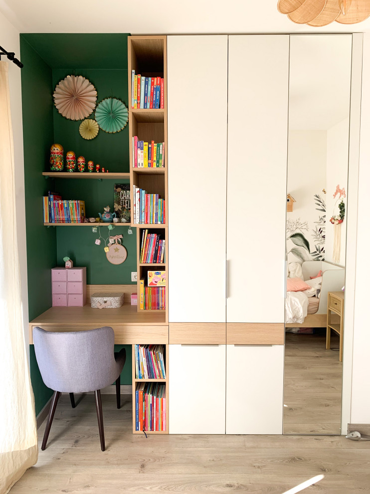 Photo of a mid-sized modern kids' bedroom for kids 4-10 years old and girls in Montpellier with green walls, laminate floors, beige floor and wallpaper.