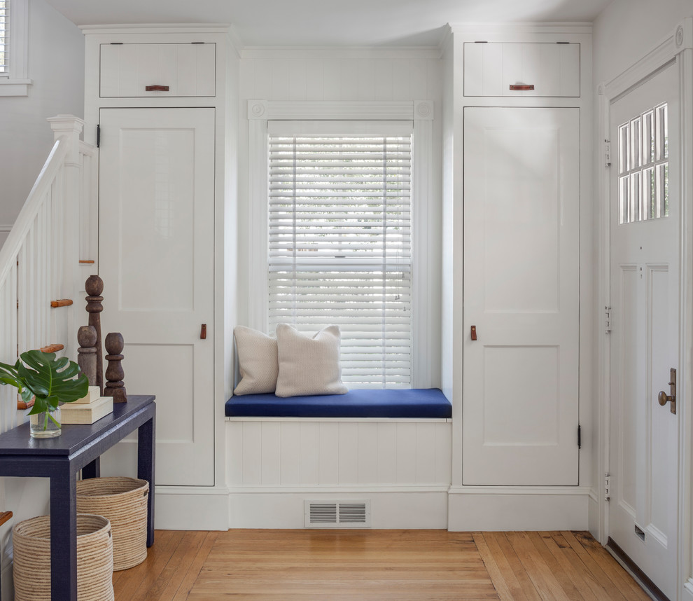 This is an example of a transitional foyer in Providence with white walls, medium hardwood floors, a single front door, a white front door and brown floor.
