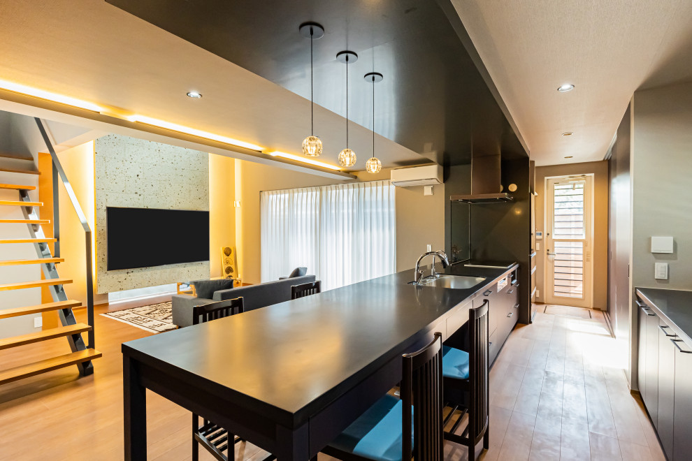 Foto di una grande cucina minimalista con ante nere, paraspruzzi nero, pavimento in legno massello medio, pavimento marrone, top nero e soffitto in carta da parati