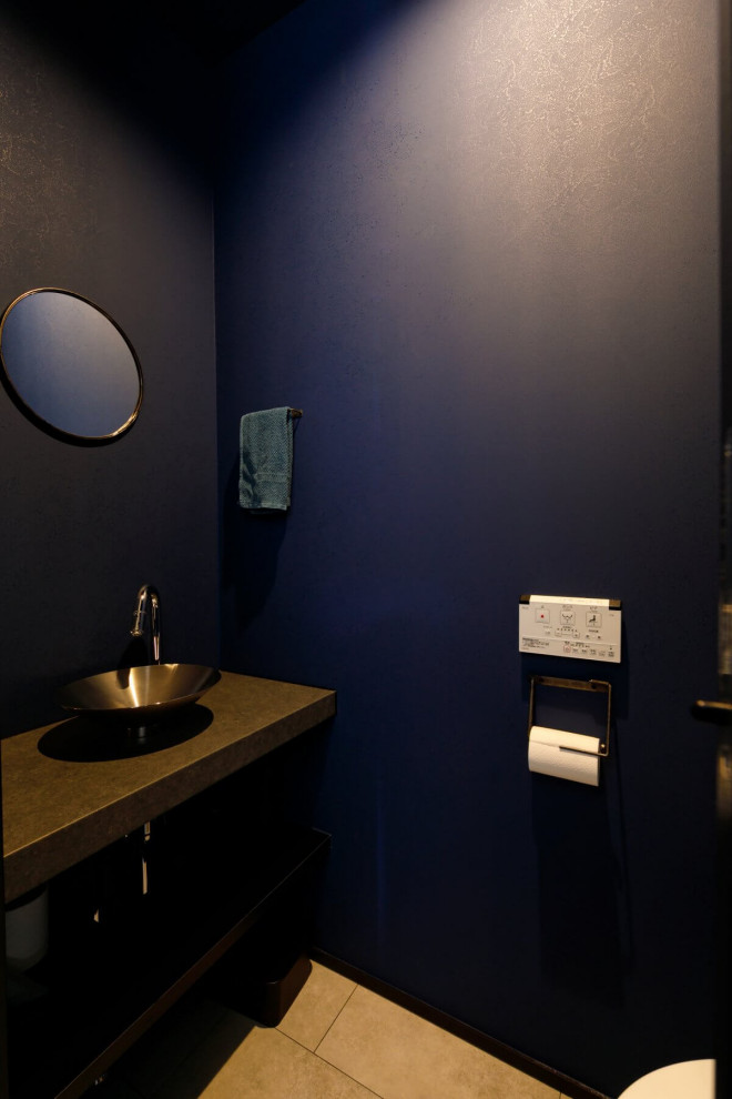 Exemple d'un WC suspendu industriel de taille moyenne avec des portes de placard marrons, un carrelage bleu, un mur bleu, une vasque, un plan de toilette marron, meuble-lavabo encastré, un plafond en papier peint et du papier peint.