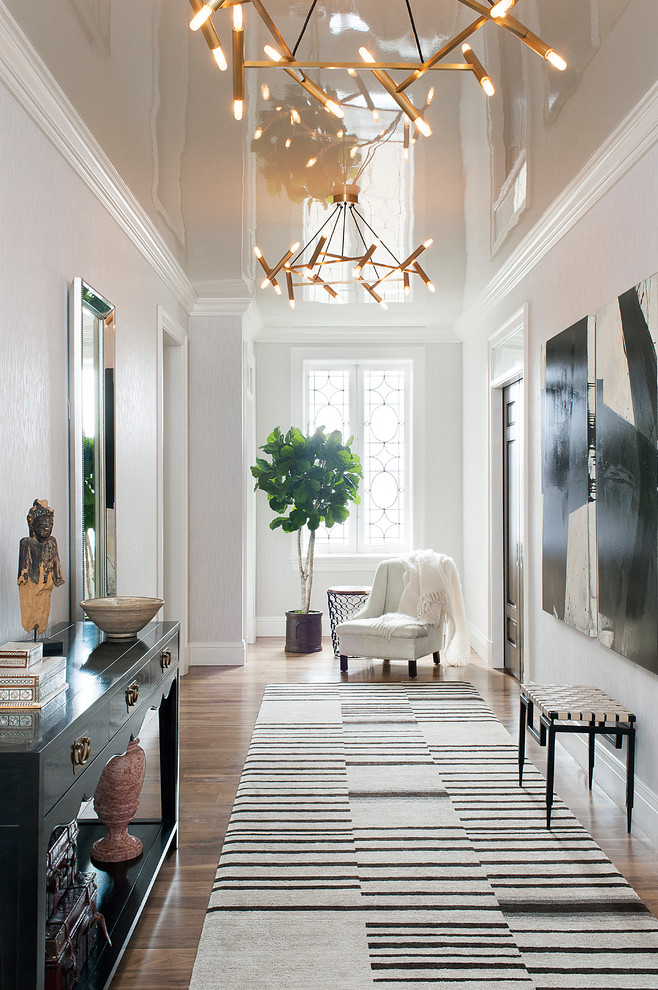 Photo of a transitional entry hall in New York with white walls, medium hardwood floors and brown floor.